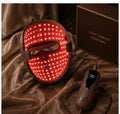 Luxera LED mask glowing warm red during an evening light session
