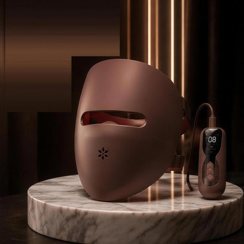 Luxéra LED mask on a marble stand beside its corded handheld controller